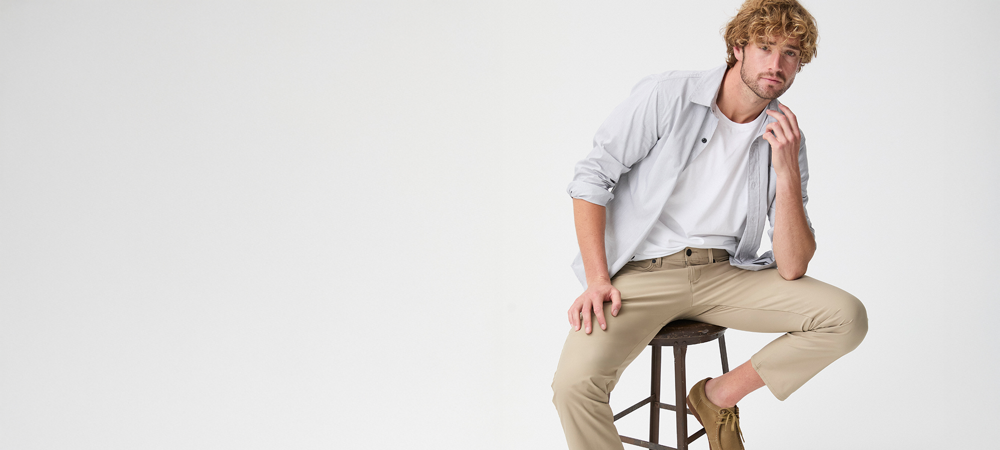 Man sitting on stool wearing Lee X clothing.
